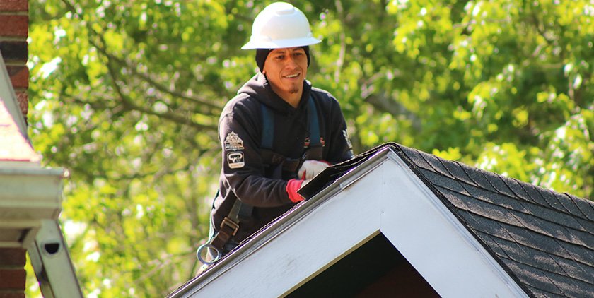 Roof inspector checking residential roof for damage in New Bedford, MA