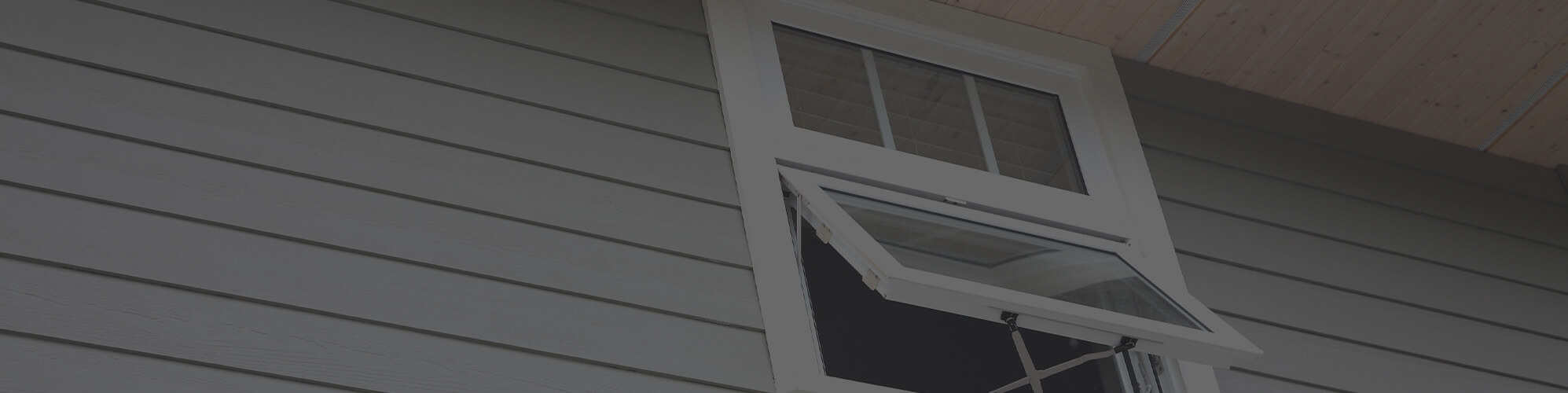 Exterior view of open hopper window on Massachusetts home